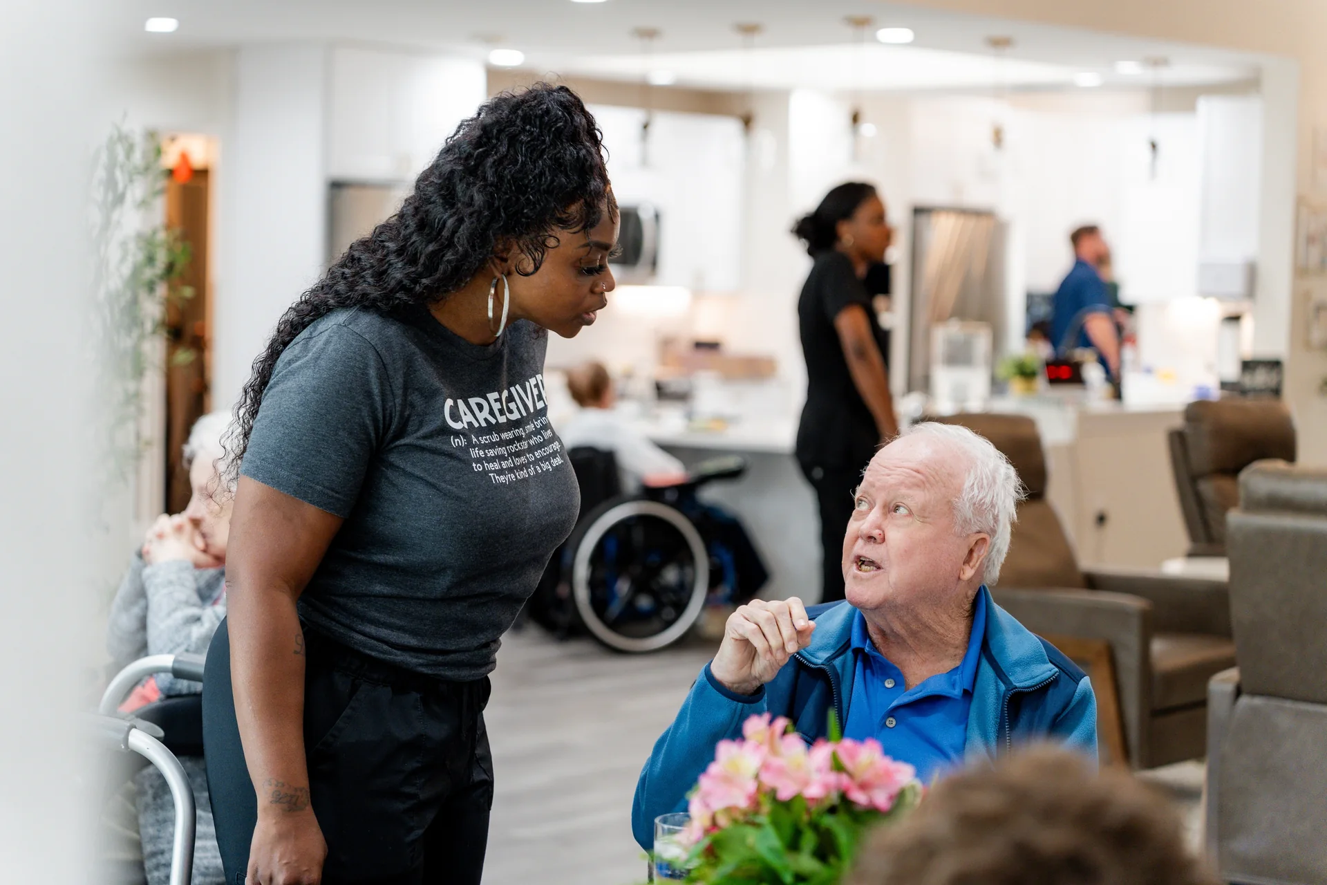 A caregiver and a resident sharing a warm conversation at home