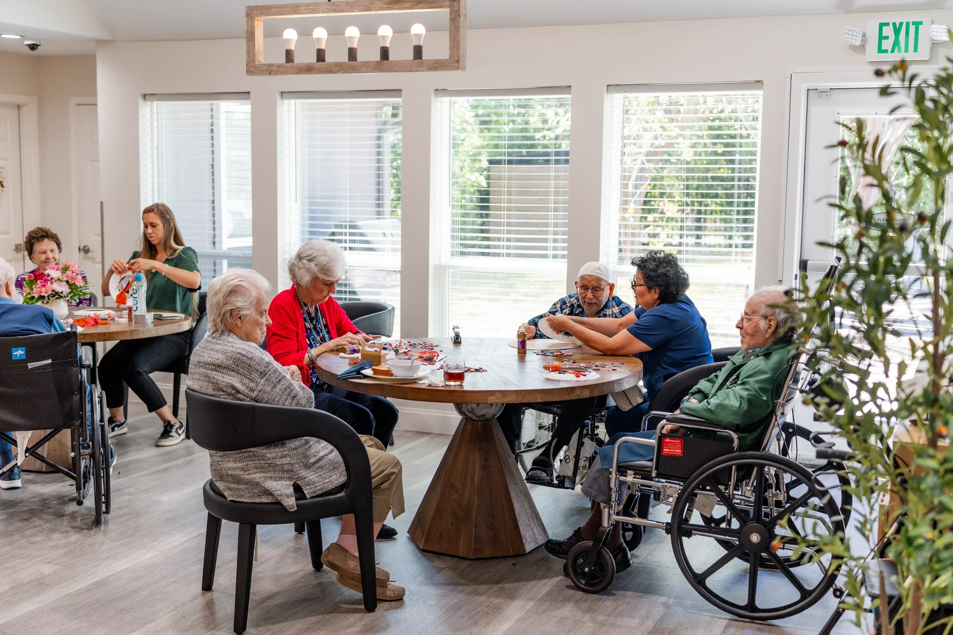 Residents and caregivers around the dining tables