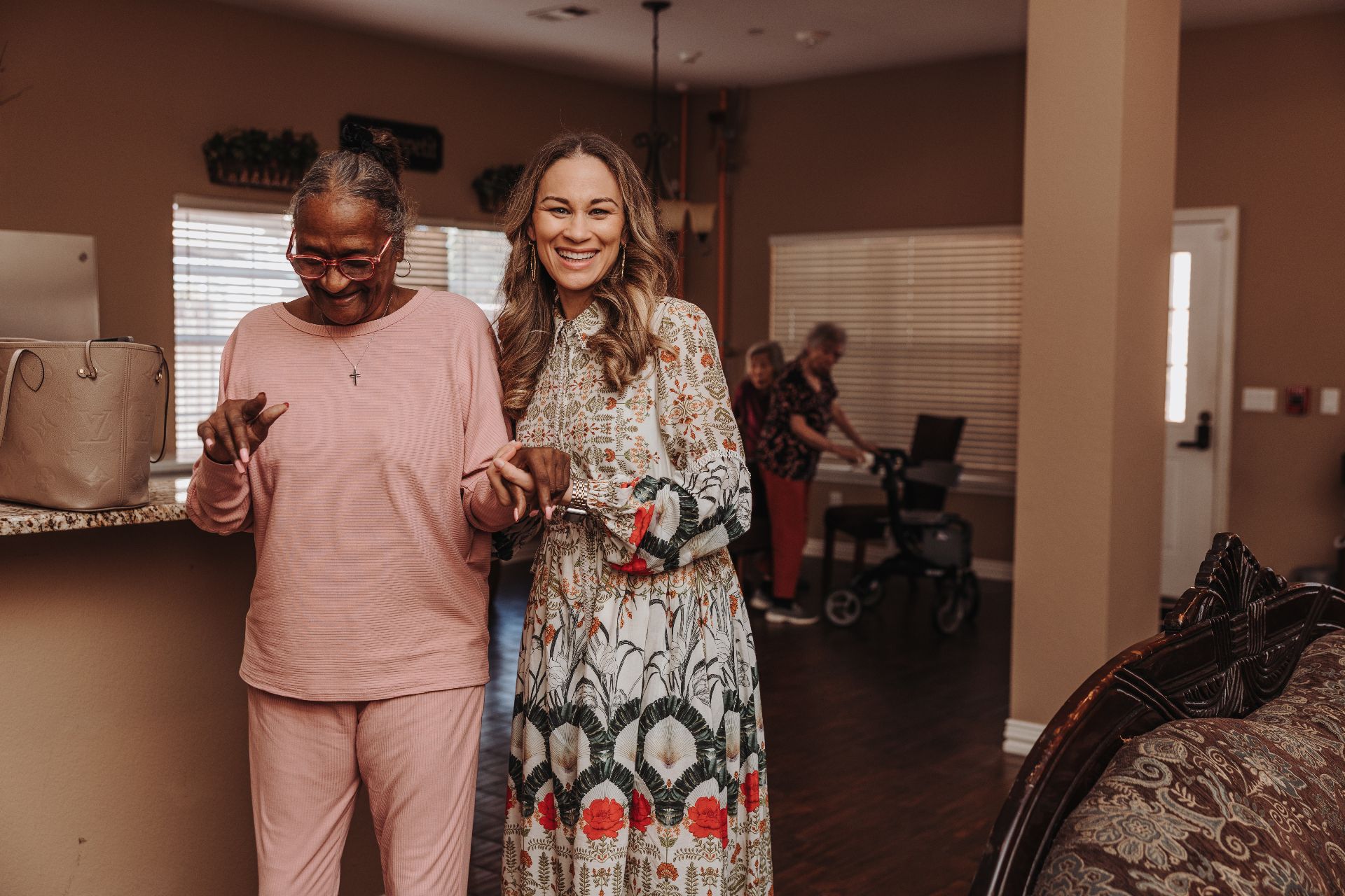 Brittany walking arm in arm with a resident
