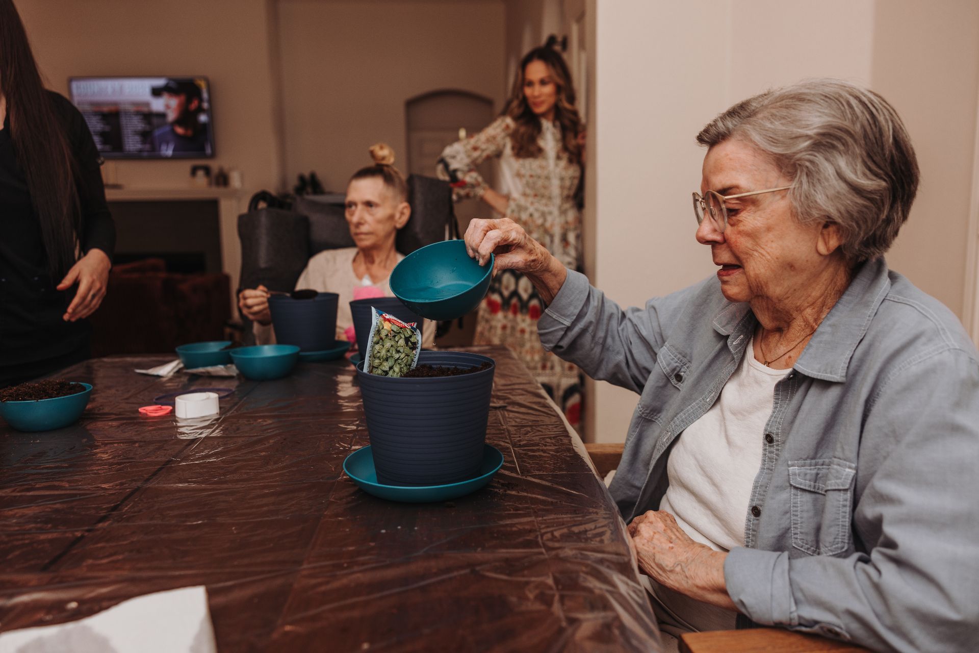 A resident planting with a caregiver nearby