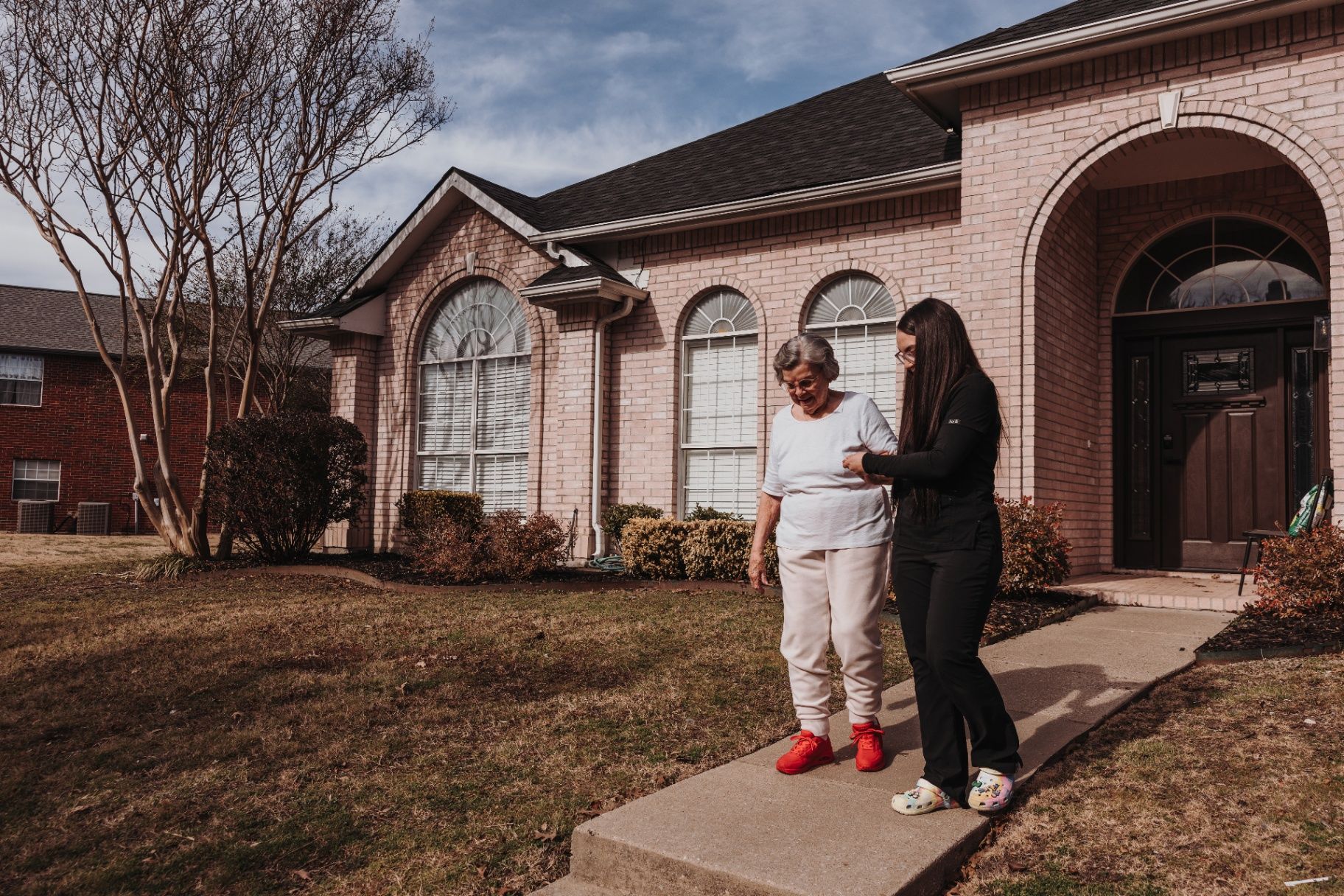 A caregiver helping a resident outside the community